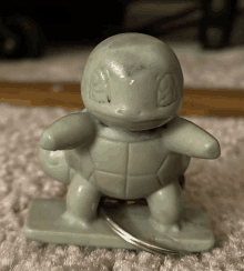 a squirtle toy is sitting on a carpeted floor