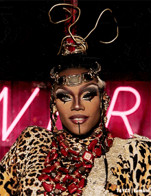a woman in a leopard print costume is in front of a neon sign that says vr