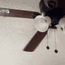 a ceiling fan is spinning on the ceiling in a room .