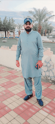 a man standing on a brick sidewalk wearing a hat that says tigers