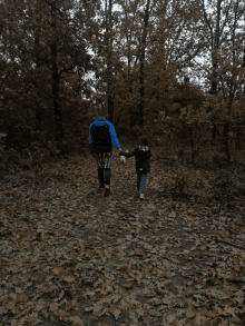 a man and a girl are walking down a path in the woods