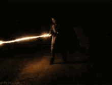 a person is standing in the dark with a fireball behind them