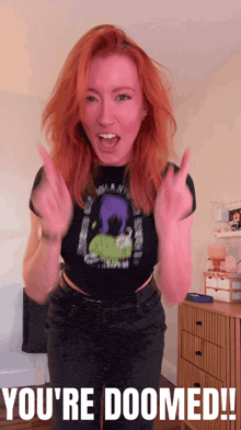 a woman with red hair is wearing a black shirt that says ' you 're doomed ' on it