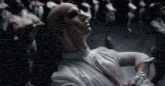 a group of people are dancing in a dark room and one of them has a bandaged head