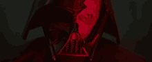 a close up of darth vader 's face with a red light coming out of his helmet .