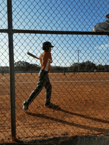 a young boy is swinging a bat in a baseball game