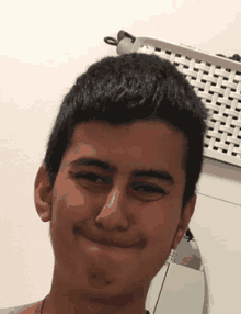 a young man smiles in front of a white basket