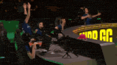 a man wearing a natura shirt is dancing in front of a monitor
