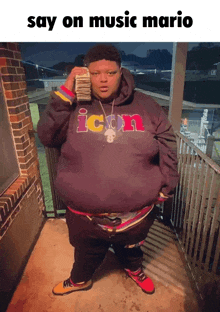 a man in an icon hoodie holds a stack of money