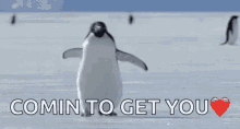 a penguin is dancing in the snow with the words `` comin to get you '' written above it .