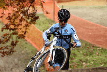 a man wearing a blue shirt with the word max on it is riding a bike