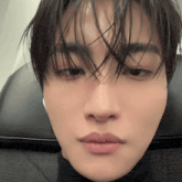 a close up of a young man 's face with a black shirt on
