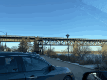 a bridge over a body of water with a car in the foreground