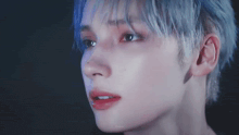 a close up of a person 's face with blue hair and red lips