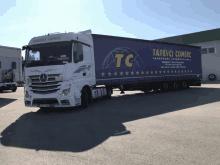 a large blue and white truck with the word tc on the side