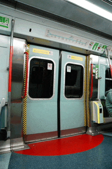 a subway car has a yellow sign on the door that says no smoking