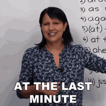 a woman is smiling in front of a white board with the words at the last minute written on it