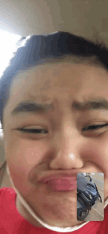 a young boy making a funny face while talking on a phone
