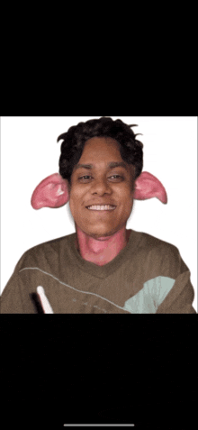 a man with large pink ears and a brown shirt