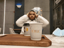 a man is sitting at a table with two cups of tonic coffee