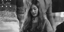 a black and white photo of a woman in a sweater with long hair .