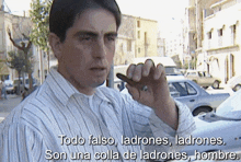 a man in a striped shirt holds a key in his hand and says todo falso