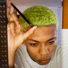 a man with green hair is holding a cell phone