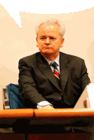 a man in a suit and tie sitting at a desk