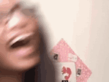 a blurry picture of a woman 's face with a playing card in the foreground .