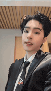 a young man wearing a suit and tie takes a selfie