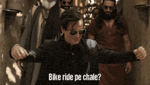 a man wearing sunglasses and a black jacket with the words bike ride pe chale