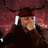 a man wearing a headband with horns on it