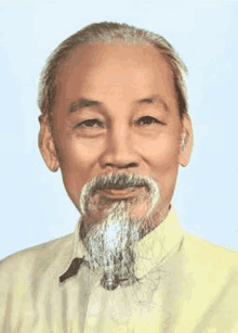 a man with a beard wearing a yellow shirt is smiling