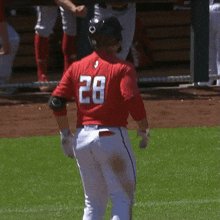 a baseball player wearing a red jersey with the number 28 on it