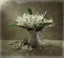 lily of the valley flowers in a pitcher with green leaves