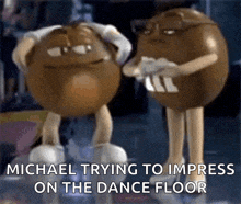 a couple of m & m 's are standing next to each other with the caption michael trying to impress on the dance floor