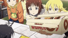 a box of donuts sits on a table in front of a group of anime girls