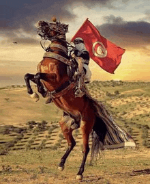 a man is riding a horse while holding a red flag .