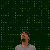 a man wearing glasses stands in front of a green background that says 13+10