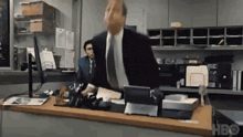 a man in a suit and tie is sitting at a desk in a office .