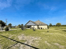 a house is sitting on top of a lush green field .