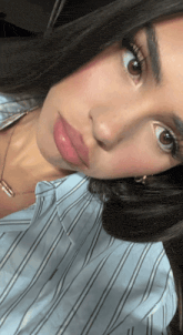 a close up of a woman 's face with a necklace around her neck