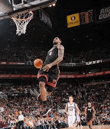 a basketball player is jumping in the air while holding a basketball .