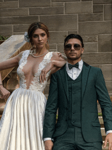 a bride in a white dress and a groom in a green suit