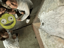 a group of people are posing for a picture with a yellow smiley face and the word friends written on the sidewalk