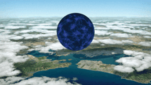 a large blue sphere is floating in the sky above a body of water