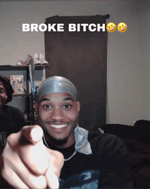 a man is pointing at the camera with the words broke bitch above him