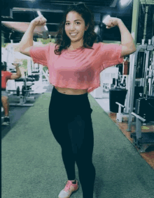 a woman flexes her muscles in a gym