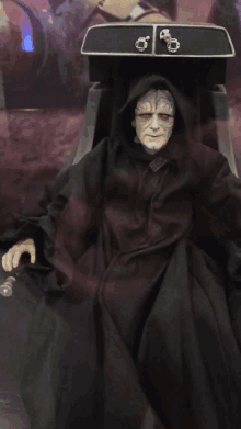 a statue of emperor palpatine from star wars sits in a chair