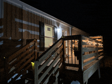 a house with stairs leading up to a porch with string lights